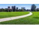 Green park with walking path, surrounded by mature trees and city buildings in the background at 1008 N Corona St # 403, Denver, CO 80218