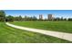Green park with walking path, surrounded by mature trees and city buildings in the background at 1008 N Corona St # 403, Denver, CO 80218