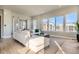 Bright living room with a comfortable white sofa, stylish rug, and expansive windows offering neighborhood views at 1764 Peak Loop, Broomfield, CO 80023