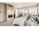 Serene main bedroom featuring a cozy fireplace, plush bedding, and large windows showcasing the neighborhood view at 1764 Peak Loop, Broomfield, CO 80023
