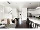 Open-concept living space with kitchen island, modern chairs, and hardwood floors at 6654 Pecos St, Denver, CO 80221