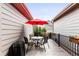 Cozy patio with table and chairs, perfect for outdoor dining and relaxation under a red umbrella at 6654 Pecos St, Denver, CO 80221