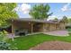 Brick home with a covered patio with hot tub and a lush lawn at 3190 S Detroit St, Denver, CO 80210