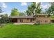 Brick home features a covered patio, a paved patio, and a lush lawn at 3190 S Detroit St, Denver, CO 80210