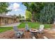 Landscaped backyard with a fire pit area surrounded by chairs, and a lush lawn at 3190 S Detroit St, Denver, CO 80210