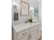 Bathroom vanity with marble countertop, white cabinetry, brushed nickel fixtures, and decorative accents at 3190 S Detroit St, Denver, CO 80210