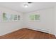 Bright bedroom featuring hardwood floors, crisp white walls, and window shutters for natural light at 3190 S Detroit St, Denver, CO 80210