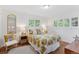 Comfortable bedroom features multiple windows with shutters, wood floors, and stylish decor at 3190 S Detroit St, Denver, CO 80210