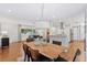 Open-concept dining area features a wooden table, modern chandelier, and flows seamlessly into the living room and kitchen at 3190 S Detroit St, Denver, CO 80210
