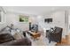 Comfortable living room featuring hardwood floors, large windows, a neutral sofa, and cozy seating at 3190 S Detroit St, Denver, CO 80210