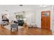 Bright living room featuring hardwood floors, a decorative front door, and stylish furnishings at 3190 S Detroit St, Denver, CO 80210