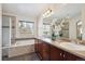 Elegant bathroom with dual sinks, large mirror, soaking tub, and separate glass shower at 22560 E Rowland Dr, Aurora, CO 80016