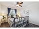 Charming bedroom features a wrought iron bed frame, ceiling fan, and bright natural light at 22560 E Rowland Dr, Aurora, CO 80016
