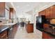 Spacious kitchen featuring wooden cabinets, black appliances, and an island with seating at 22560 E Rowland Dr, Aurora, CO 80016