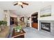 Comfortable living room with fireplace, kitchen access, and large windows for natural light at 22560 E Rowland Dr, Aurora, CO 80016