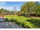 Beautifully landscaped back yard with mature trees and green grass at 860 Quintana Ln, Erie, CO 80516
