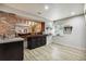 Basement with a brick trimmed bar, wooden countertop, cabinets, sink, and plank floors at 860 Quintana Ln, Erie, CO 80516