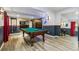 Basement game room with a pool table, bar, and plank floors at 860 Quintana Ln, Erie, CO 80516