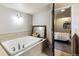 Soaking tub with tile surround and access to adjoining bedroom at 860 Quintana Ln, Erie, CO 80516