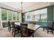 Elegant dining room featuring a large wooden table, bench seating, modern lighting, and stylish decor at 860 Quintana Ln, Erie, CO 80516