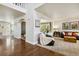 Open-concept living room with hardwood floors, neutral walls, plenty of natural light, and a comfortable seating arrangement at 860 Quintana Ln, Erie, CO 80516
