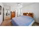 Bright bedroom with ceiling fan, carpet flooring, light walls and blue comforter. Door leads to an attached bathroom at 10223 Vine Ct, Thornton, CO 80229