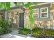 Inviting entrance with stone facade, a gray front door, and lush landscaping at 10223 Vine Ct, Thornton, CO 80229
