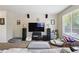 Comfortable living room featuring large windows, entertainment center, and cozy pet beds at 10223 Vine Ct, Thornton, CO 80229