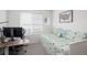 Bright bedroom features a daybed with floral bedding, a desk, and a large window for ample natural light at 203 S Oak Hill St, Aurora, CO 80018
