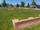 Community garden plot with raised garden bed boxes surrounded by green grass at 203 S Oak Hill St, Aurora, CO 80018