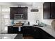 Modern kitchen featuring dark cabinets, stainless steel appliances, and granite countertops at 203 S Oak Hill St, Aurora, CO 80018