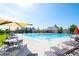 Community swimming pool with lounge chairs, umbrellas, and tables surrounding it at 203 S Oak Hill St, Aurora, CO 80018