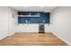 Finished basement with a bar area featuring a white countertop, blue accents, and a wine fridge at 2999 S Adams St, Denver, CO 80210