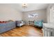 A Bedroom with a gray dresser, crib, rocking chair, and window with natural light at 2999 S Adams St, Denver, CO 80210