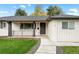 Charming home entrance with a walkway, dark door, and well-manicured lawn at 2999 S Adams St, Denver, CO 80210