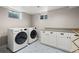 Bright laundry room with patterned tile floor, new washer and dryer and countertop at 2999 S Adams St, Denver, CO 80210