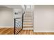 Staircase with hardwood steps, black metal railing and entry to finished basement at 2999 S Adams St, Denver, CO 80210