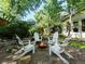 This backyard gathering space features a fire pit surrounded by Adirondack chairs, plus lush landscaping at 1985 Union St, Lakewood, CO 80215