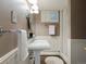 Cozy bathroom featuring pedestal sink, wood paneled lower walls, and classic fixtures and lighting at 1985 Union St, Lakewood, CO 80215