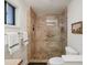 Modern bathroom with travertine shower, mosaic tile flooring, and glass door at 1985 Union St, Lakewood, CO 80215