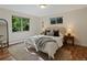 Sunlit bedroom with hardwood floors, a plush rug, and two windows providing natural light at 1985 Union St, Lakewood, CO 80215
