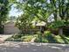 Charming ranch home featuring mature trees, beautiful landscaping, and a welcoming covered porch at 1985 Union St, Lakewood, CO 80215