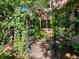 A beautifully landscaped backyard garden path leading through an arbor towards the home at 1985 Union St, Lakewood, CO 80215