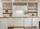This kitchenette is fitted with white cabinetry and countertops, and has wood shelving for storage at 1985 Union St, Lakewood, CO 80215