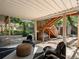 This backyard patio area features modern outdoor furniture, a wooden staircase, and lush greenery at 1985 Union St, Lakewood, CO 80215
