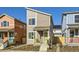 Two-story modern home with gray siding, yellow porch, and landscaping at 10251 E 62Nd Pl, Denver, CO 80238