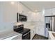 Modern kitchen with white cabinets and stainless steel appliances at 10251 E 62Nd Pl, Denver, CO 80238