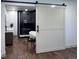 Elegant bathroom with a sliding barn door, soaking tub, and sleek fixtures at 14546 Pine View Rd, Larkspur, CO 80118