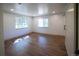 Bright bedroom featuring wood floors, two windows, and a barn-style sliding door at 14546 Pine View Rd, Larkspur, CO 80118