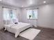 Bright bedroom with wood floors, a white comforter, minimalist decor, and natural light from two windows at 14546 Pine View Rd, Larkspur, CO 80118
